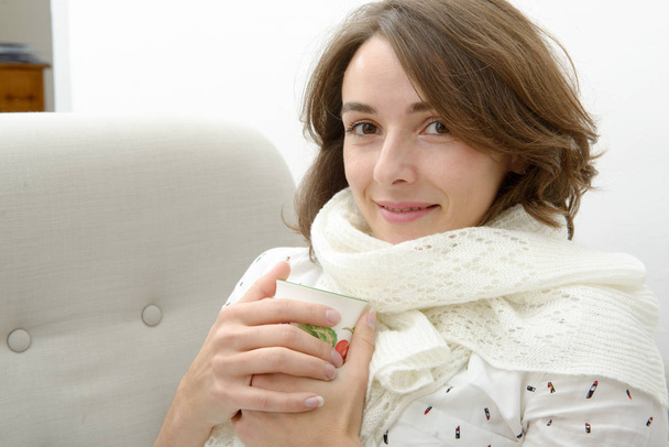 красива молода жінка з чашкою чаю в дивані
 - Фото, зображення