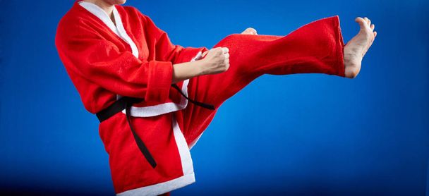 Im Anzug des Weihnachtsmannes schlägt die Sportlerin auf Tritte ein - Foto, Bild