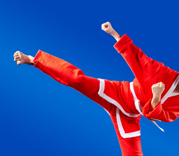 В костюме Санта-Клауса взрослый спортсмен бьет ногами
 - Фото, изображение