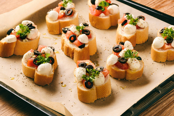 Toasts with mozzarella, tomatoes, olives and garlic. - Foto, immagini