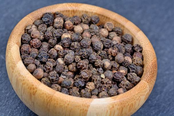 Black pepper in a bamboo bowl - Photo, Image