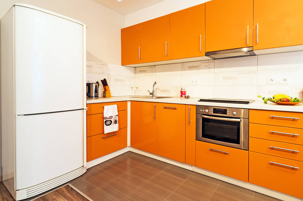 cucina moderna arancione con pareti bianche e una grande finestra. - Foto, immagini