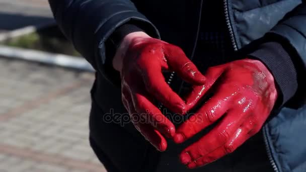 ein Mann hebt seine Hand in der Farbe bis zum Gesicht im Park draußen - Filmmaterial, Video