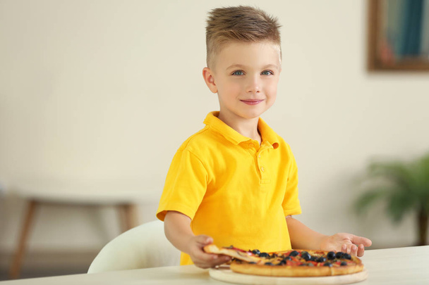 Cute boy eating pizza at home - Foto, Imagen