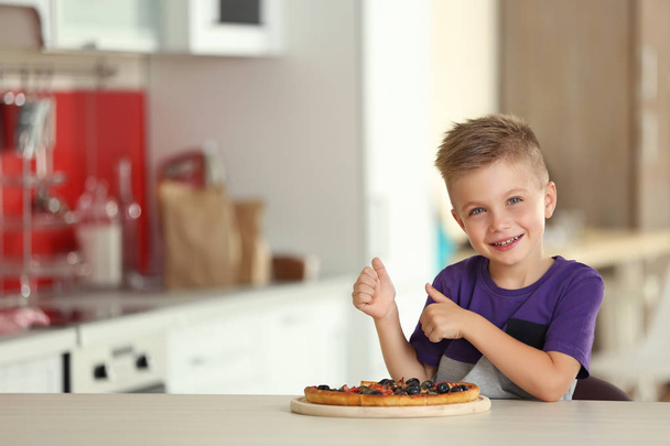 Cute boy with hot pizza at home - Zdjęcie, obraz
