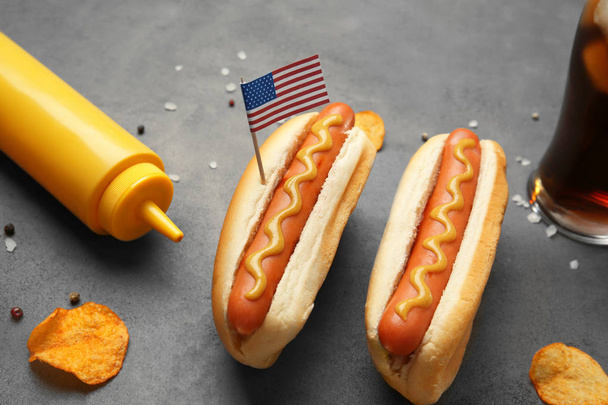 Hot dogs with mustard and small USA flag on grey background - Φωτογραφία, εικόνα