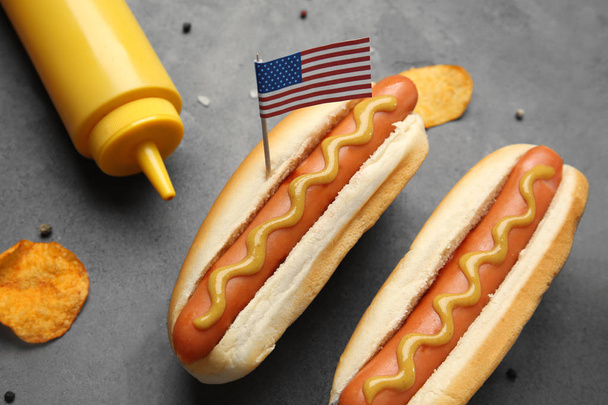 Hot dogs with mustard and small USA flag on grey background - Foto, immagini