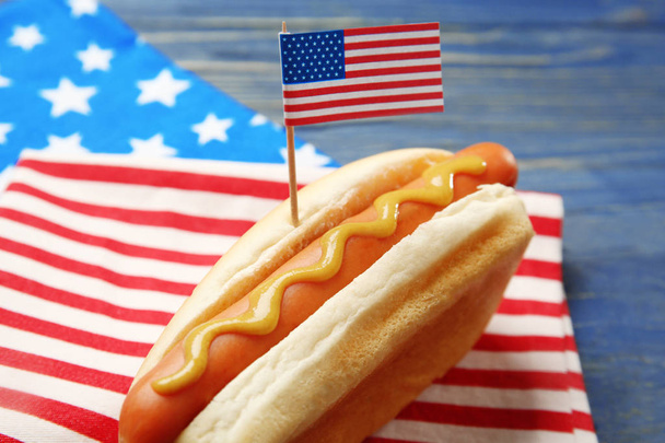 Hot dog with mustard and small USA flag on napkin - Foto, Imagen