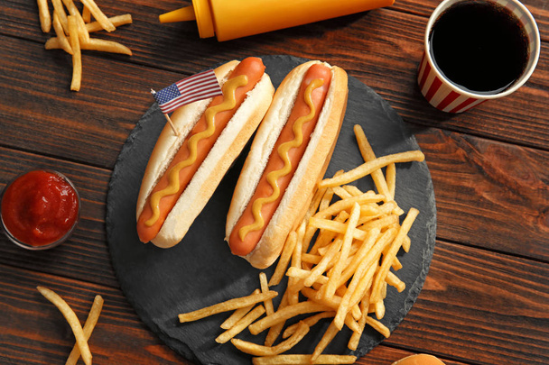 Hot dogs with mustard and small USA flag on slate plate - Foto, Imagen