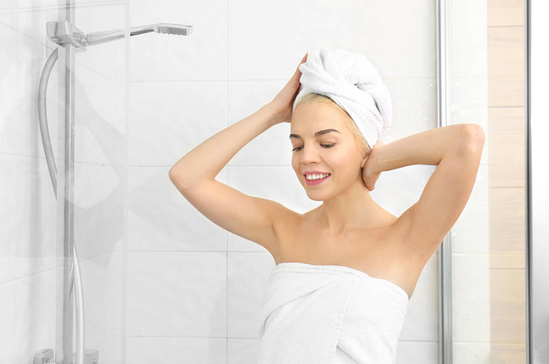Beautiful young woman in towel going to shower - Fotografie, Obrázek