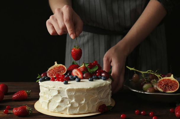 Baker hand decorating creamy cake - Fotó, kép