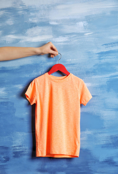 hand holding blank orange t-shirt  - Фото, зображення