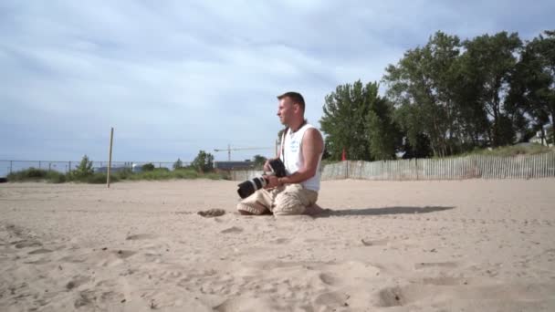 Φωτογράφος σε δράση. Επαγγελματία φωτογράφο υπαίθρια. Παραλία φωτογράφος - Πλάνα, βίντεο