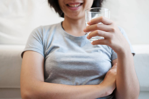 Frau hält Glas Wasser zum Trinken in der Hand. - Foto, Bild