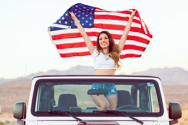 Happy Young Girl Standing In Convertible Car Holding Waving American Flag. - Foto, Imagem