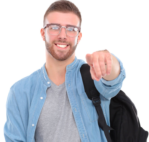 Young male student with a school bag holding books and pointing you isolated on white background - Φωτογραφία, εικόνα