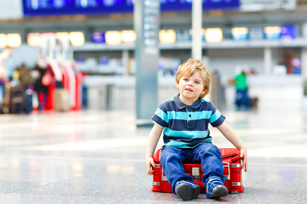 Niño pequeño que va de vacaciones viaje con maleta en el aeropuerto
 - Foto, imagen