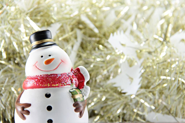 Симпатичный снеговик на золотой стример или мишура фон
 - Фото, изображение