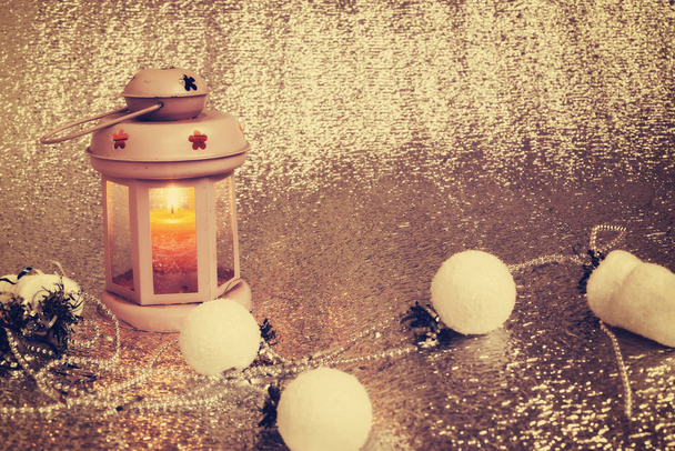 alte Laterne mit brennender Kerze steht auf silbernem Hintergrund - Foto, Bild