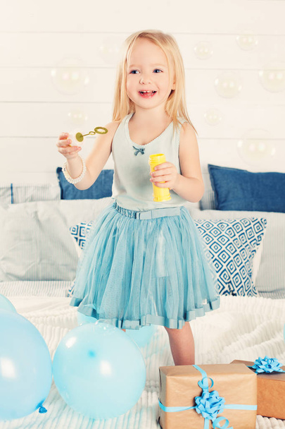  Směje se holčička vyfukování bublin. Roztomilé dítě doma - Fotografie, Obrázek
