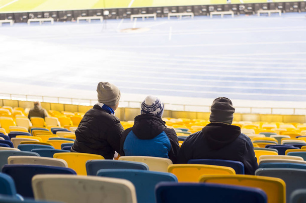 Deje sentarse en el estadio viendo a los aficionados al fútbol
 - Foto, Imagen