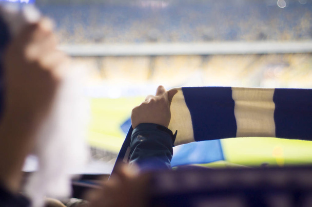 шанувальники стадіону тримають прапори своєї футбольної команди
 - Фото, зображення