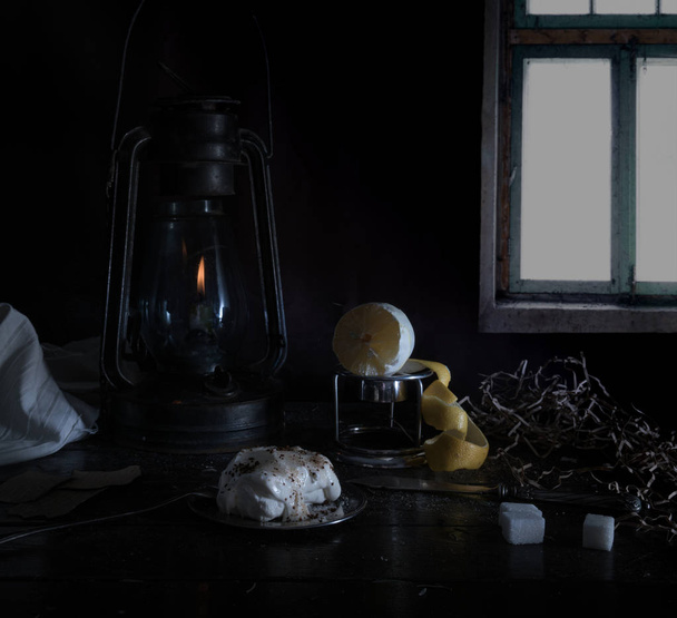 still life. Small Dutch. kerosene lamp with purified lemon and sugar on a wooden table against the window - Foto, Imagem