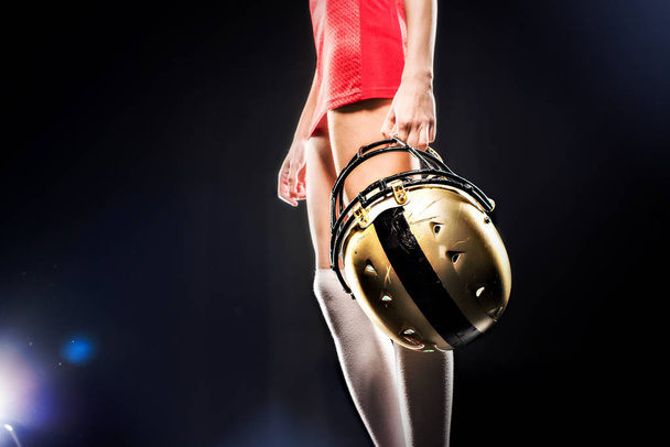 Female football player holding helmet - Фото, изображение
