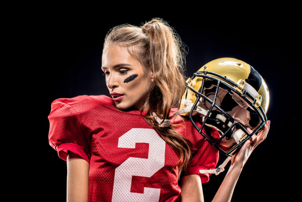 Female football player posing with helmet - Fotó, kép