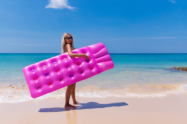 Mujer rubia delgada con colchón de aire playa tropical
 - Foto, imagen