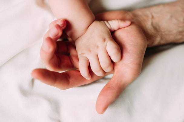 trzymając ręce miłości ojca z chłopca 4-6 miesięcy jego syn  - Zdjęcie, obraz