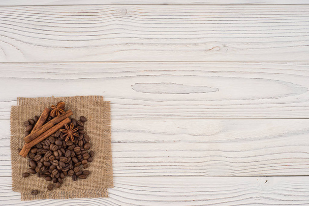 Coffee beans with cinnamon and star anise on an old wooden table - Photo, Image