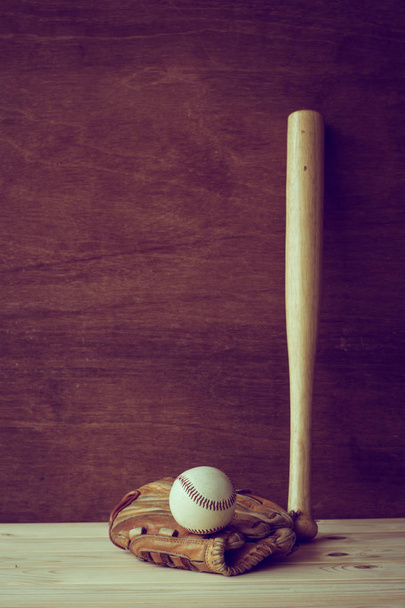 бейсбольна бита з рукавичкою і м'ячем на дерев'яному фоні
 - Фото, зображення