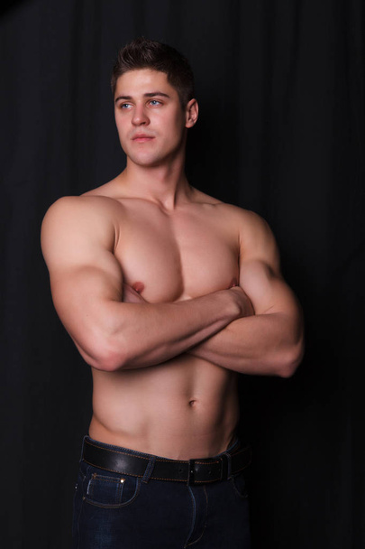 sports guy with a naked torso on a black background - Photo, Image