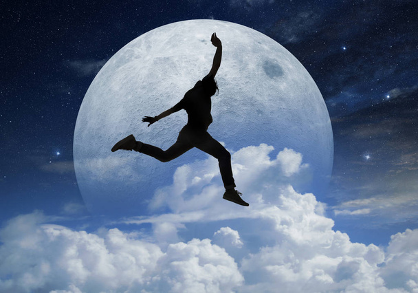 young man jumping in front a full moon - Foto, Bild