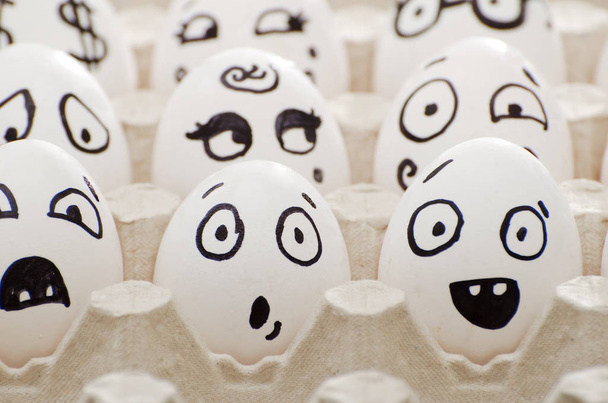 Eieren met geschilderde emoties in de lade, close-up - Foto, afbeelding