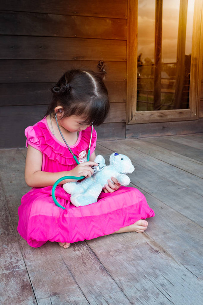 Aranyos ázsiai lány játszik, orvos vagy a nővér medve plüss játék  - Fotó, kép