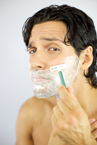 Handsome cool man scared of shaving face - Foto, afbeelding
