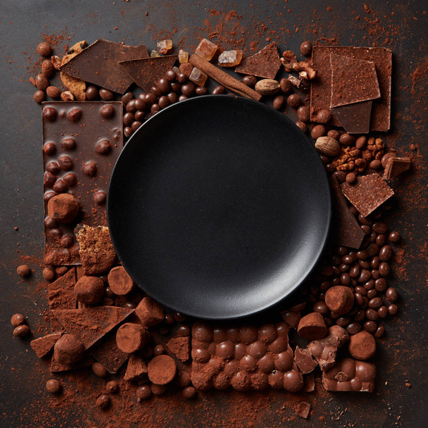 frame of different chocolates with black plate - Photo, image