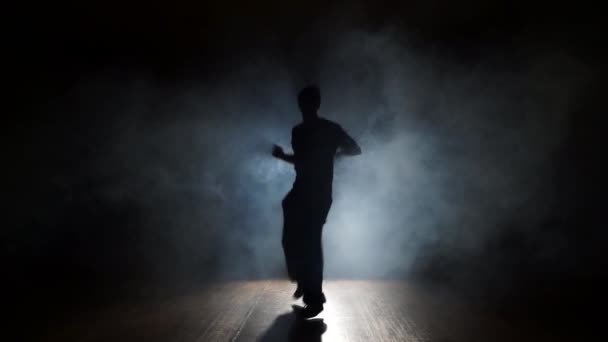 Mężczyzna tańczy taniec modny w dym - Materiał filmowy, wideo