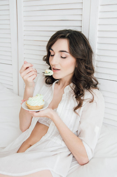 Girl eats cake for Breakfast in bed  - Zdjęcie, obraz