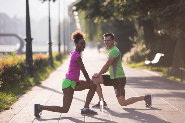 jogging couple warming up and stretching in the city - 写真・画像