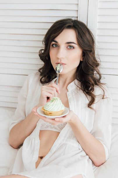 Girl eats cake for Breakfast in bed  - Fotoğraf, Görsel