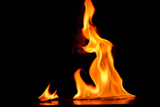 Hermosas llamas de fuego sobre un fondo negro. - Foto, imagen