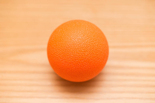木のテーブルの上にオレンジ色の小さなマッサージ ボール - 写真・画像