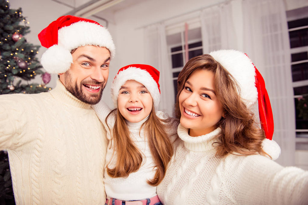 Karácsonyi selfie a mosolygó családi viselt santa kalap - Fotó, kép
