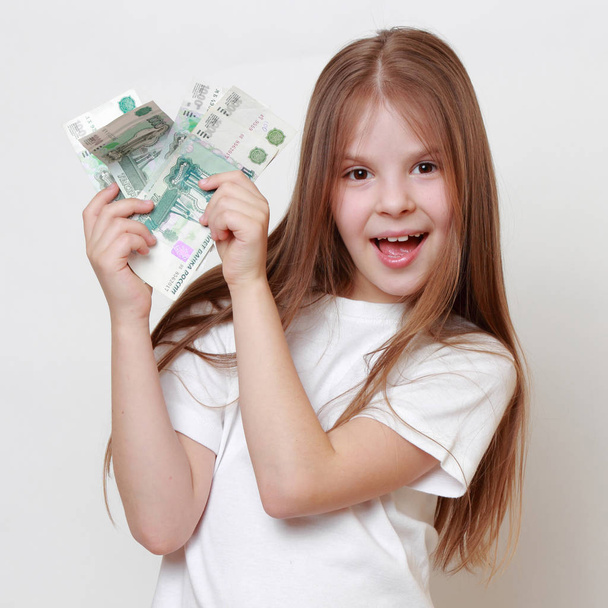 European beautiful little girl holding russian cash money - Φωτογραφία, εικόνα