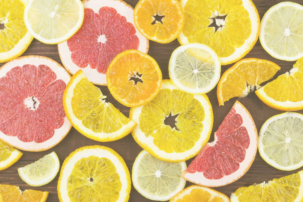 Various citrus: orange, lemon, tangerine, grapefruit on a dark background. Top view. Food background. Toning. - Foto, Imagem
