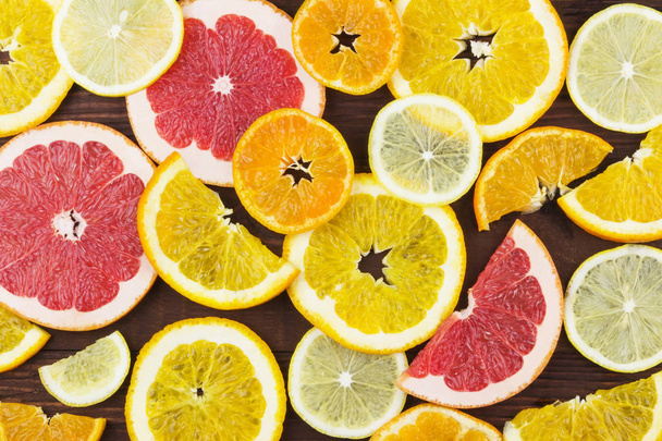 Various citrus: orange, lemon, tangerine, grapefruit on a dark background. Top view. Food background. - Foto, Imagem
