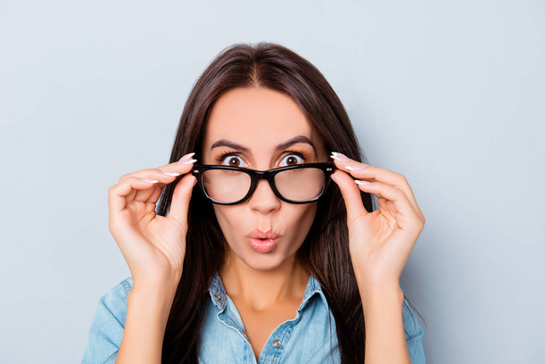 Wow! Shocked pretty woman touching her glasses  - Photo, image